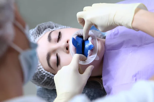 Ο οδοντίατρος διεξάγει επαγγελματική στοματική υγιεινή για ένα νεαρό κορίτσι. Πρόληψη τερηδόνας. Ένα νεαρό κορίτσι στο ραντεβού με τους οδοντιάτρους. Επαγγελματικός καθαρισμός δοντιών. — Φωτογραφία Αρχείου