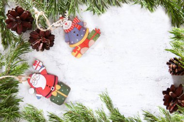 Arka planda koni ve Noel oyuncakları olan çam dalları. Farklı arabalar şeklinde ahşaptan yapılmış oyuncaklar. Yeni yıl ya da Noel konsepti. Noel kartı. Düz plan. El yapımı Noel süslemeleri.