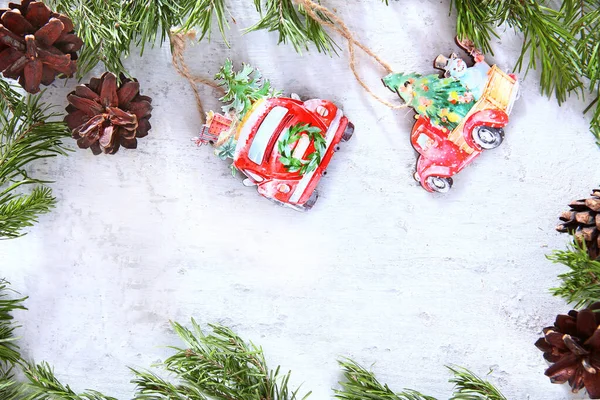 Toys made of wood and pine cones on a light background. Pine or spruce branches. The concept of New year or Christmas. Christmas card. Flat layout. Copy space.Handmade Christmas tree decorations.