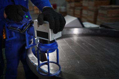 Lazer oyması tamamlanmış yatağın üzerine. Ağır endüstri konsepti. Fabrikadaki fotoğraf. Tanımlanamayan kişi. Boşluğu kopyala.