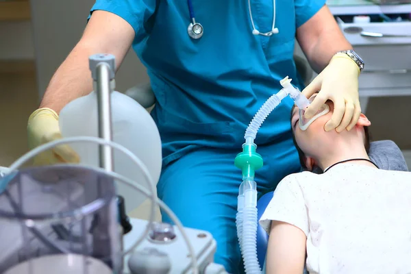 Το παιδί είναι υπό αναισθησία κατά τη διάρκεια της επέμβασης. Ο αναισθησιολόγος έχει μάσκα αναπνοής στο πρόσωπο των αγοριών. Έννοια της υγειονομικής περίθαλψης και της διάσωσης. — Φωτογραφία Αρχείου