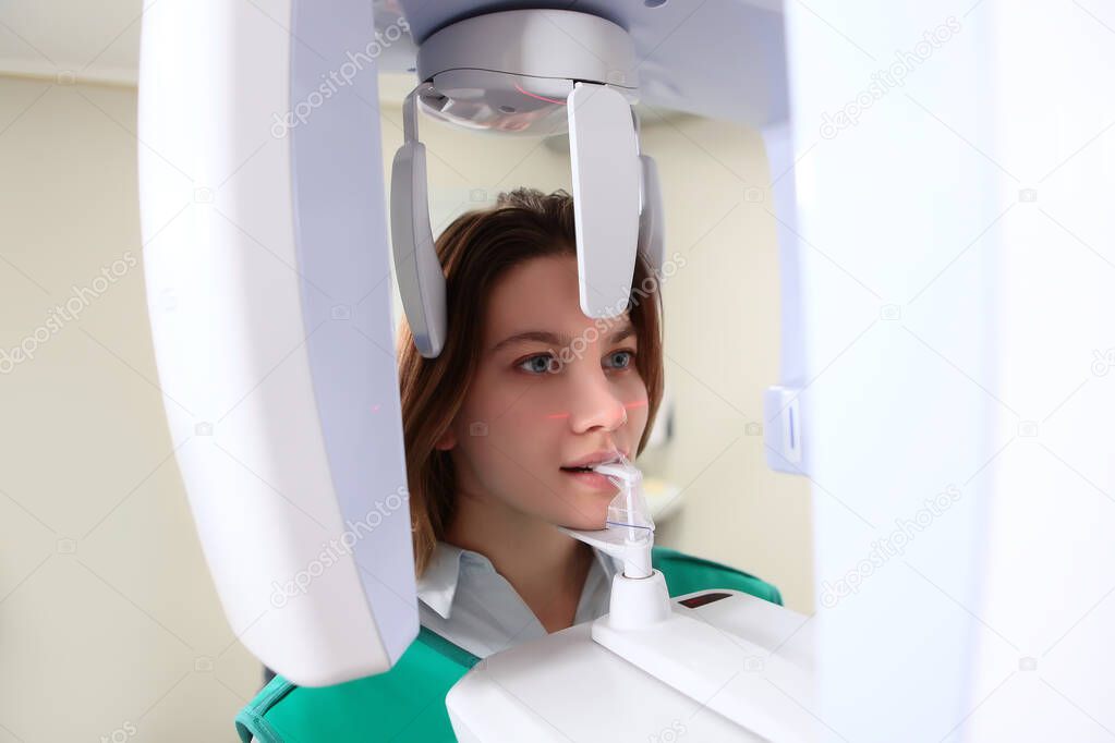 The girl takes a panoramic picture of the jaw in the dental laboratory. The concept of health and beauty. Prevention and treatment of teeth. Top view. Copy space.