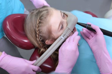 Diş kliniğinde azot oksit kullanımı. Cerrahi ya da diş ameliyatlarından önce hastanın gevşemesi. Çocukların modern dişçiliği. Sağlık hizmetleri kavramı. Fotoğrafın yatay yönelimi.