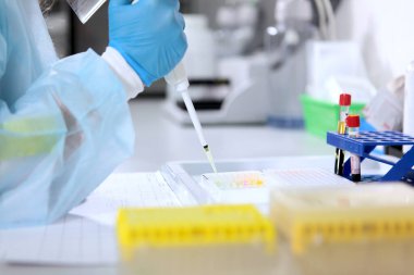 Göz damlasıyla laboratuvar teknisyeninin eli. Klinik ve tanı laboratuvarı. Ellerinizi koruyucu eldivenlere koyun. Sağlık hizmetleri kavramı. Aşıların test ve geliştirilmesi.