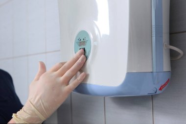 Sağlık çalışanı, odanın ultraviyole radyasyon cihazını çalıştırıyor. Sağlık ve bakım kavramı. Klinikte tanınmayan bir kişi..