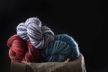 Siyah arka planda çok renkli yün iplik. El örgüsü için iplik. Hobi kavramı. Boş alan..