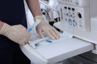 Tıbbi cihazları yerleştirmek için vantilatör panelini çekin. Trakeostomi tüpüyle kapatılmış torba. Genel anestezi altında ameliyata hazırlanıyor. Yapay akciğer havalandırma cihazı. Tanımlanamayan kişi..