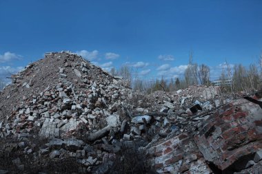 Mavi gökyüzüne karşı inşaat enkazı. Yıkılmış bir tuğla duvar. Binanın enkazı. Çevre kirliliği kavramı. Boşluğun bir kopyası.