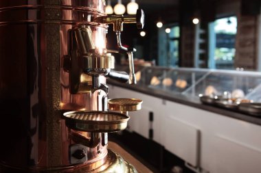 Kafenin içinde büyük bir antika bakır kahve makinesi var. Antika tarzı. İnsansız fotoğraflar. Boş alan.