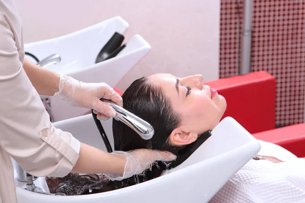 Güzellik salonunda saç ve saç bakımı. Islak, uzun saçlı. Saç için spa tedavisi. Güzellik kavramı. Berber müşterinin saçını yıkar..