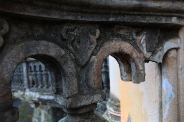 Eski bir evin yıkılmış balkonunun bir parçası. Beton eski balyalar. Duvar çürüme, alçı ve küf izleri gösteriyor. Odaklanamıyorum. Yakın plan..
