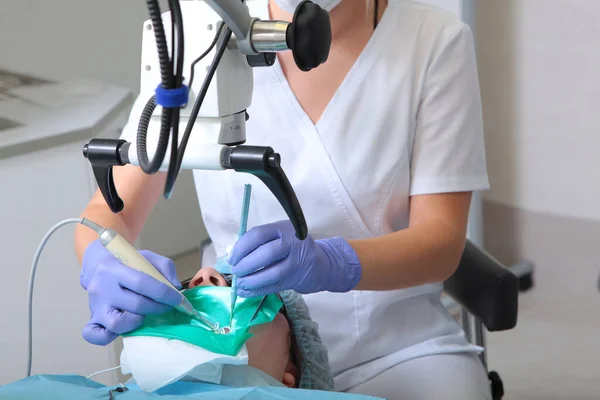 Tratamento dentário com microscópio.Odontologia moderna. Tratamento preciso de doenças complexas.Tratamento de inflamação profunda e passagem de canais dentários.Uma pessoa irreconhecível. — Fotografia de Stock
