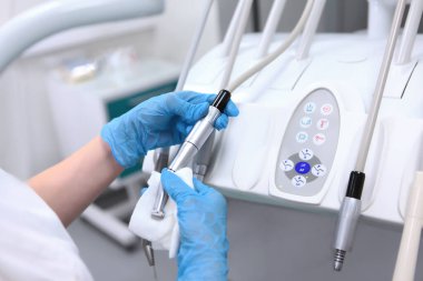 Diş asistanı hareket ettirilebilir diş kolunu aletlerle siler. Diş teçhizatı dezenfeksiyonu. Sağlık hizmeti konsepti. Tanınmayan kişi.