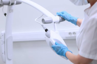 Diş teçhizatı dezenfeksiyonu. Diş hekimi asistanı diş beyazlatma aletlerini siliyor. Sağlık hizmeti konsepti. Eller koruyucu eldivenlerde..