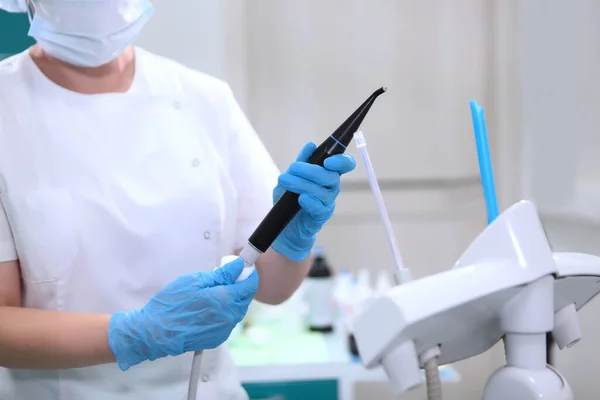 歯科助手は歯科用ハンドピースを拭く 歯科機器の消毒 ヘルスケアの概念 保護手袋の手 認識できない人 — ストック写真