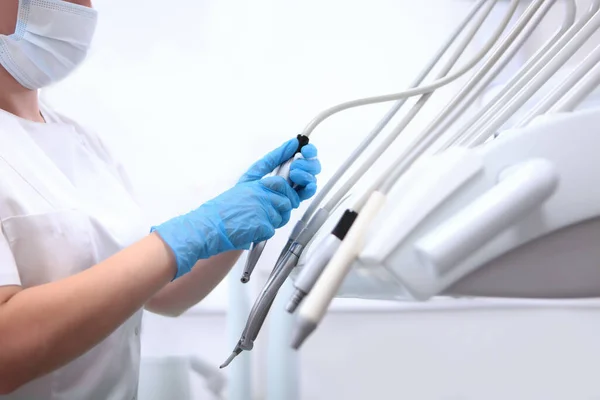 歯科機器の消毒 歯科助手は可動式の歯科腕を計器で拭く ヘルスケアの概念 保護手袋付きの手だけ — ストック写真