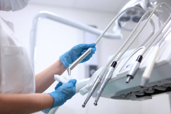 歯科機器の消毒 歯医者の助手は可動式の器具棚を拭く ヘルスケアの概念 保護手袋の手だけ — ストック写真