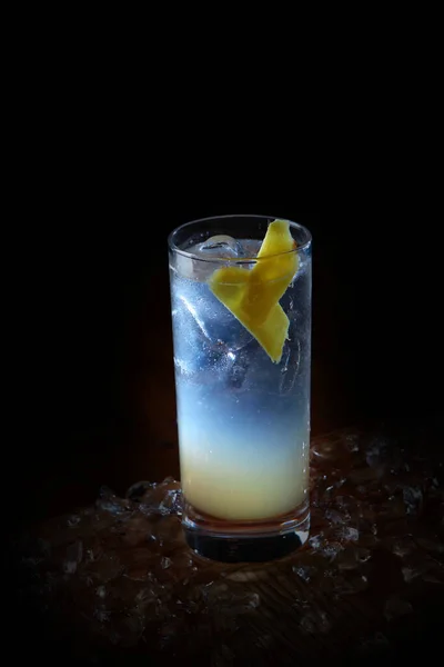 Homemade lemonade with ginger in a tall glass. Vertical photo on a black background. Copy space. — Stock Photo, Image