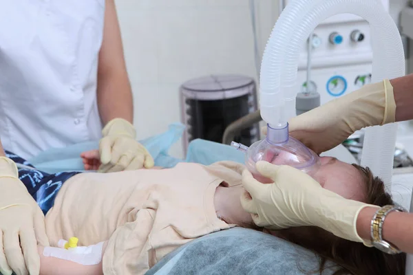 Προετοιμασία του παιδιού για χειρουργική επέμβαση. Μάσκα οξυγόνου στο πρόσωπο. Αγνώριστοι άνθρωποι. Σώζω ζωές. Συσκευές τεχνητού εξαερισμού. — Φωτογραφία Αρχείου