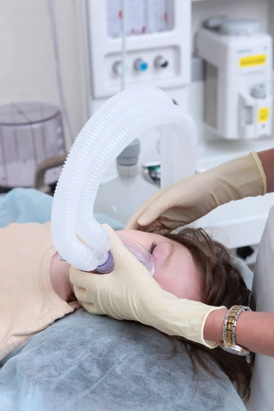 Az aneszteziológus-újraélesztő általános érzéstelenítésben mutatja be a gyermeket. Egy gyerek oxigénmaszkkal az arcán. A gyermek felkészítése a műtétre. — Stock Fotó