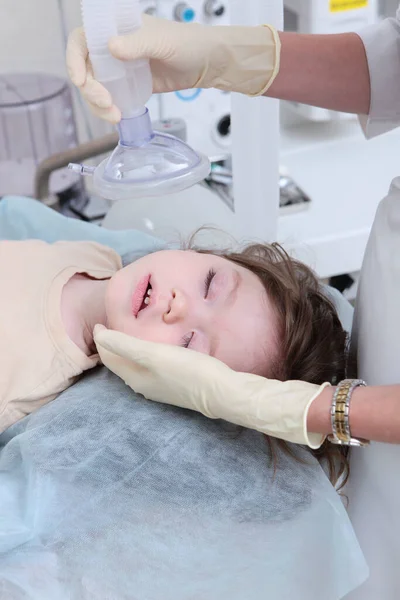 Příprava dítěte na operaci v celkové anestezii. Umělý plicní ventilační přístroj. Kyslíková maska v rukou lékaře. — Stock fotografie