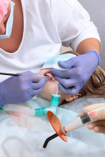 Θεραπεία τερηδόνας των πρωτοπαθών δοντιών υπό γενική αναισθησία. χειρουργική επέμβαση με γενική αναισθησία. Ένα παιδί υπό γενική αναισθησία. Κάθετη φωτογραφία. — Φωτογραφία Αρχείου