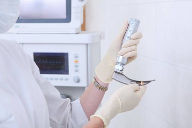 Nefes borusu entübasyonu için bir anestezi uzmanı ve canlandırıcı gerekli. Ellerinizi koruyucu eldivenlere koyun. Ameliyata hazırlanıyorum. Yapay akciğer havalandırması için bir cihaz. Boşluğu kopyala.