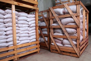 Deponun içi. Bir depoda depolanmış ürünler. Ahşap raflar. Paketler depodaki rafların üzerinde duruyor. Toptan ürünlerin poşetlerde depolanması.