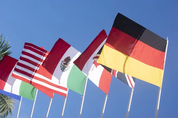 青い空の前を飛ぶイタリア イギリス カナダ メキシコ アメリカ ドイツの国旗 — ストック写真