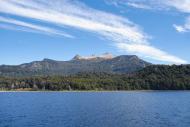 Beyaz bulutlu ve Şili 'de mavi gökyüzü olan arka planda dağlar olan panoramik bir göl manzarası. Seyahat ve macera konsepti.