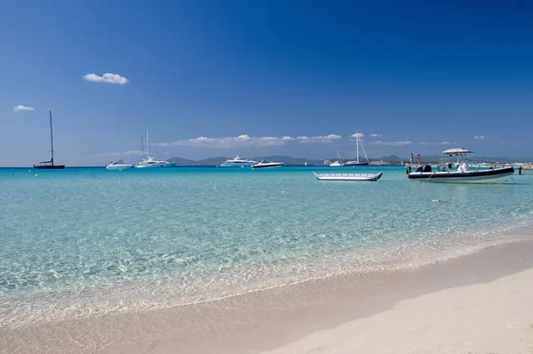 İspanya 'nın Formentera adasındaki Illetes Plajı. Arka planda demirli tekneler ve mavi gökyüzü