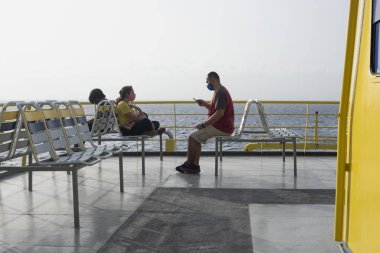 Meksika 'daki Karayip Denizi' nde bir feribotun açık güvertesinde oturan aile gezisi.