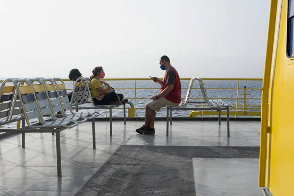 Meksika 'daki Karayip Denizi' nde bir feribotun açık güvertesinde oturan aile gezisi.