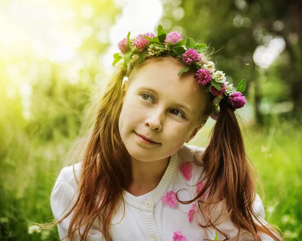 Preciosa chica pensativa en una corona de flores —  Fotos de Stock