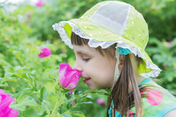 Мила маленька дівчинка вдихає аромат квітки — стокове фото