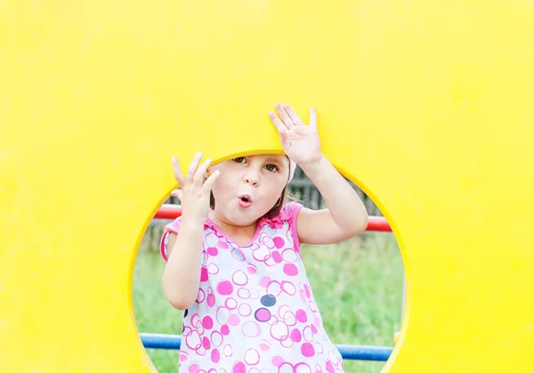 Menina sorrindo bonito espreitando pela janela — Fotografia de Stock