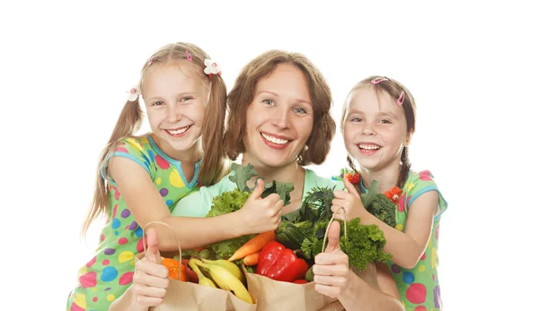 Счастливая семья мать и дочери с мешками овощей — стоковое фото