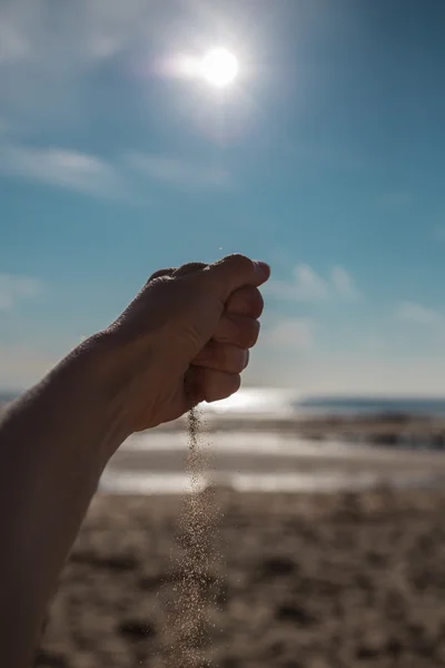 Sand falling from the woman's hand — Stock Photo, Image