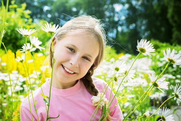 Красива молода дівчина на лузі в оточенні ромашок — стокове фото
