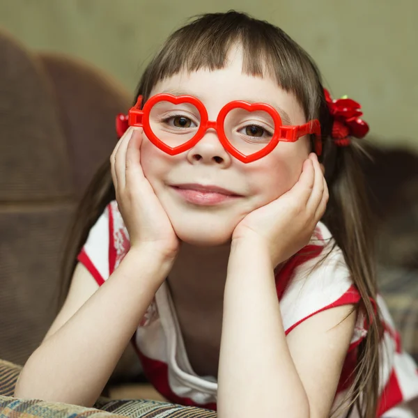 Preciosa niña sonriente en gafas en forma de corazón —  Fotos de Stock