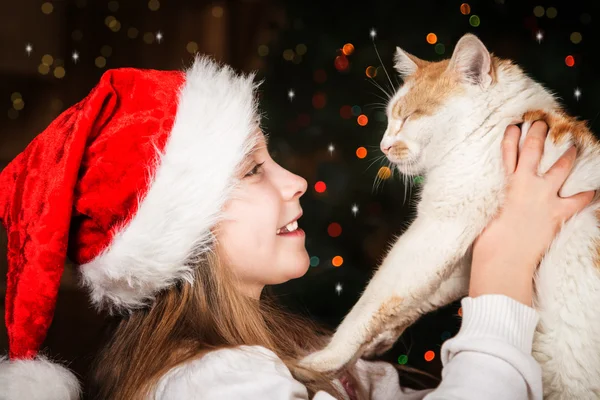 Счастливая маленькая девочка с любимой кошкой на Рождество — стоковое фото