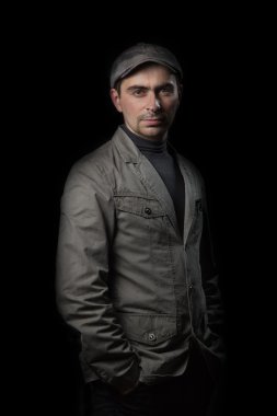 Ceket ve kap ceplerinde elele siyah bir arka plan üzerinde ciddi adam