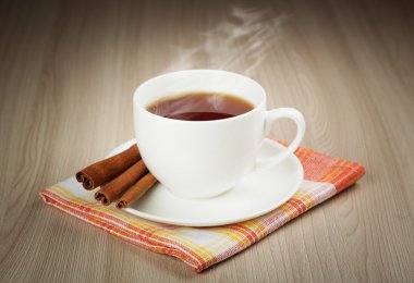 Hot cup of warming tea with cinnamon clipart