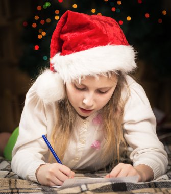 Sevimli küçük bir kız heyecanla Noel Baba'ya bir mektup yazar