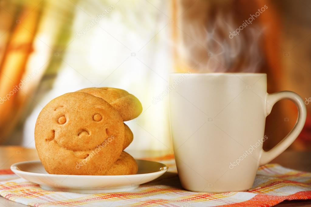 Breakfast for positive mood. A hot drink and biscuit with a smile