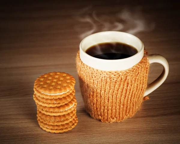 Bebida caliente en una taza con una ropa de punto y galletas con relleno —  Fotos de Stock