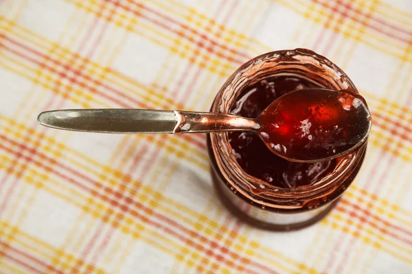 Marmellata di fragole su un cucchiaio in banca — Foto Stock