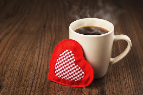 Gran taza de bebida caliente y corazón textil en una mesa de madera. El concepto de vacaciones de San Valentín —  Fotos de Stock