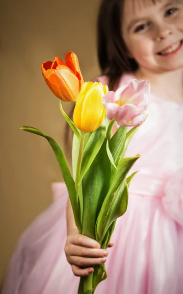 Три тюльпани в дитячих руках — стокове фото