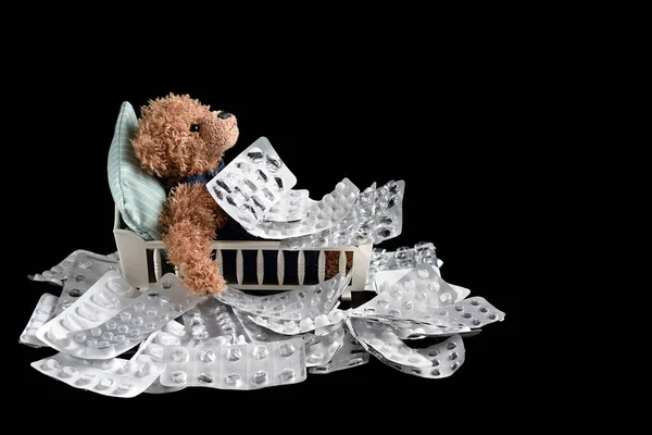 Lege Medicijnblaren Een Teddybeer Bed Grond Rond Het Bed Geïsoleerd — Stockfoto